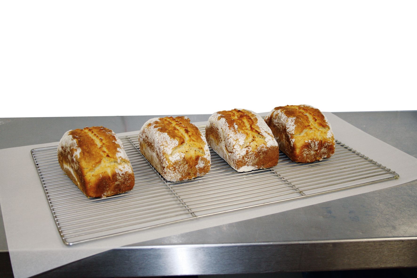 Four loaves of bread are sitting on a wire rack