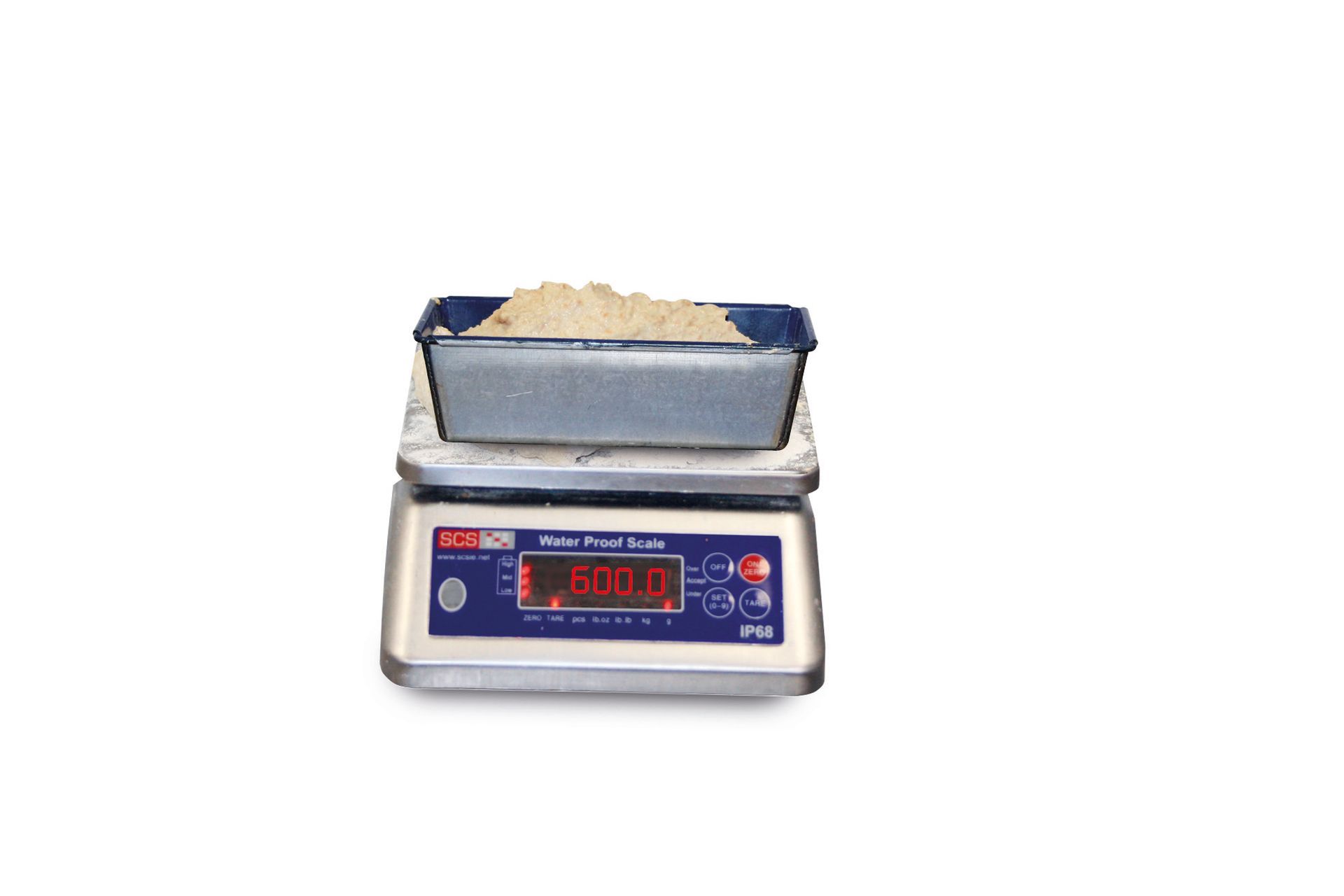 A digital scale with a tray of rice on top of it.