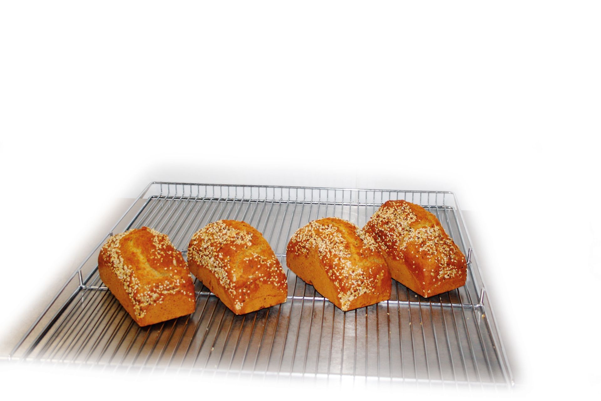 Four loaves of bread are sitting on a cooling rack