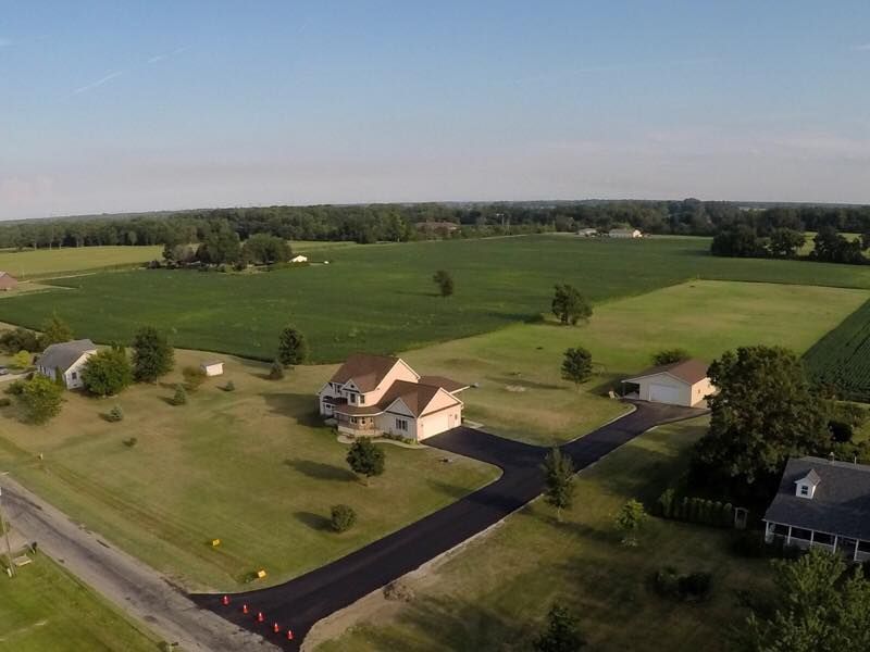 An aerial view of a house in the middle of a field