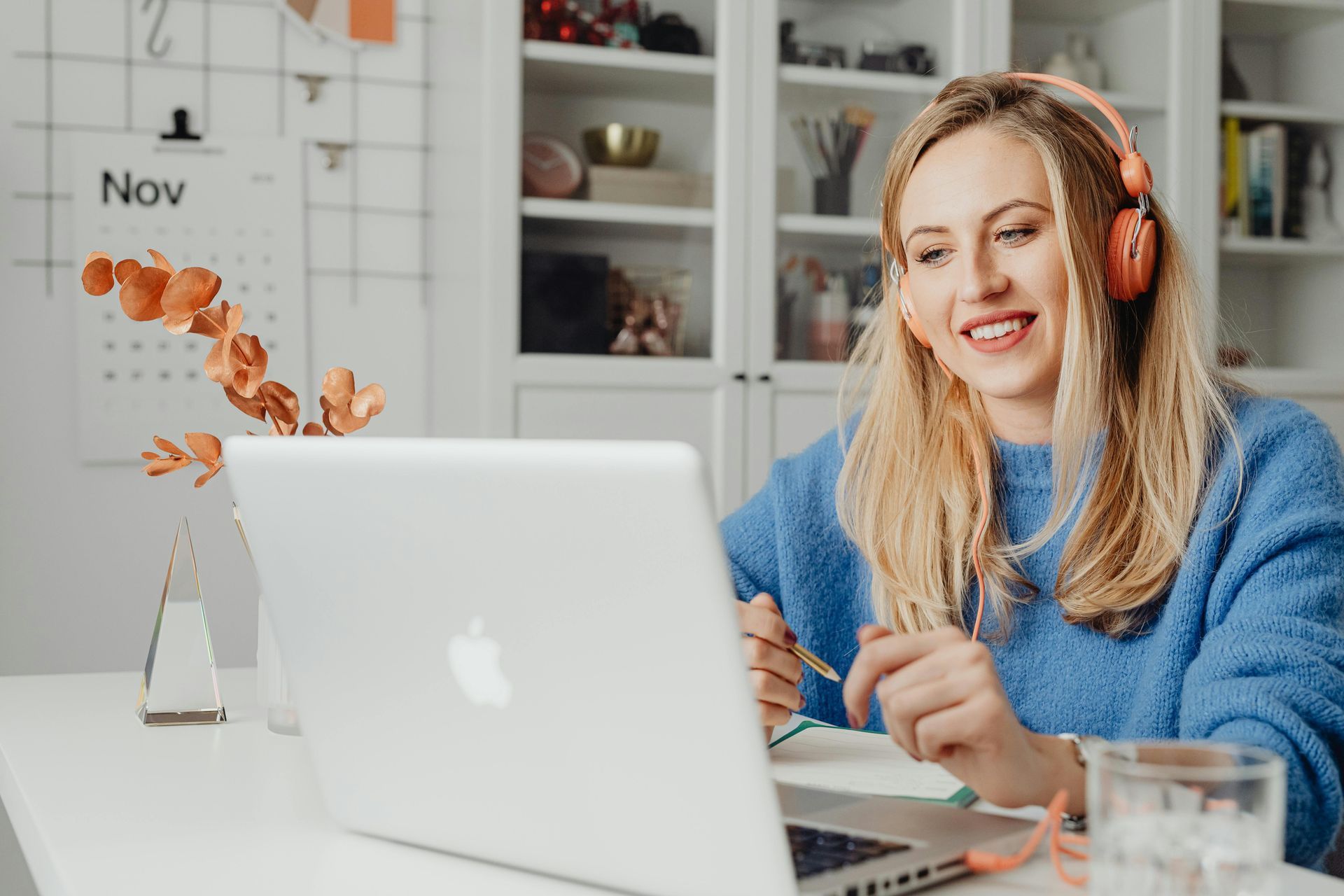 A woman wearing headphones is sitting in front of a laptop computer.