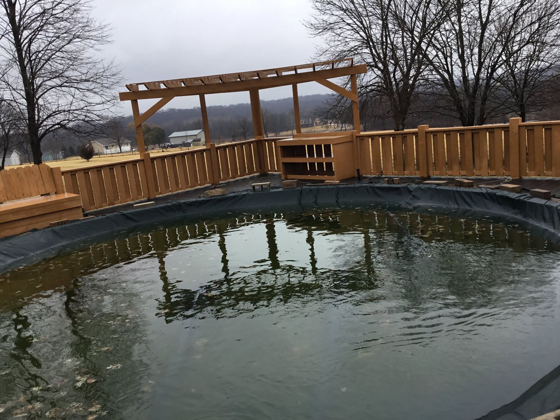 A large pond with a wooden fence around it