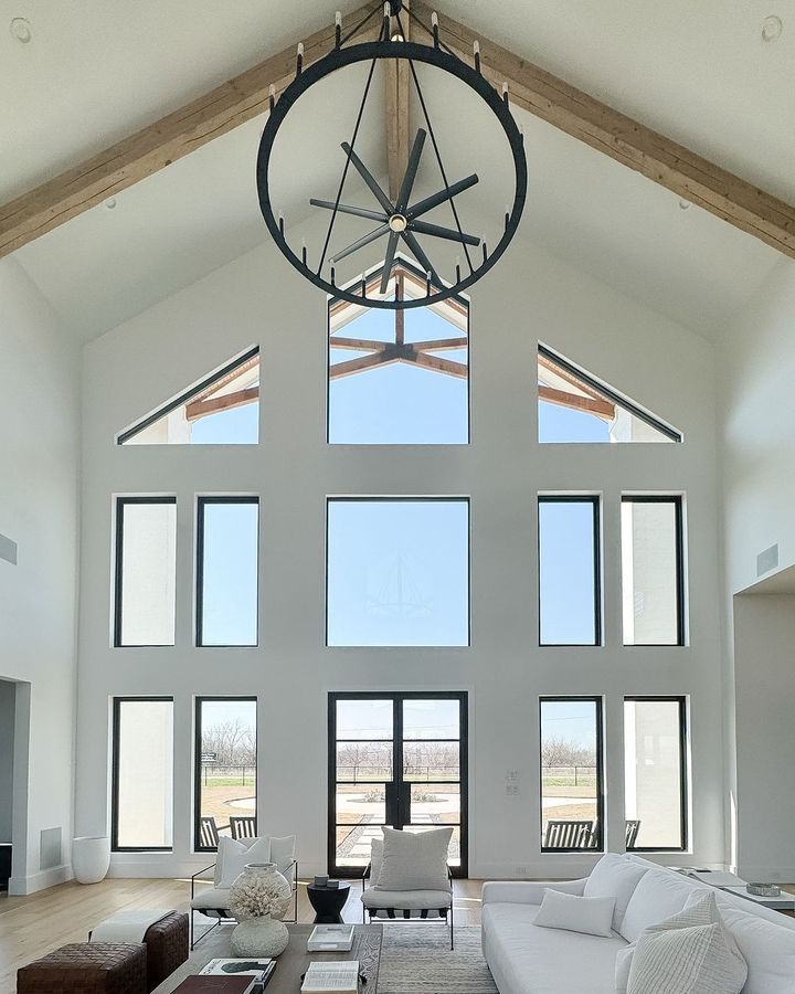 A living room with a lot of windows and a chandelier hanging from the ceiling