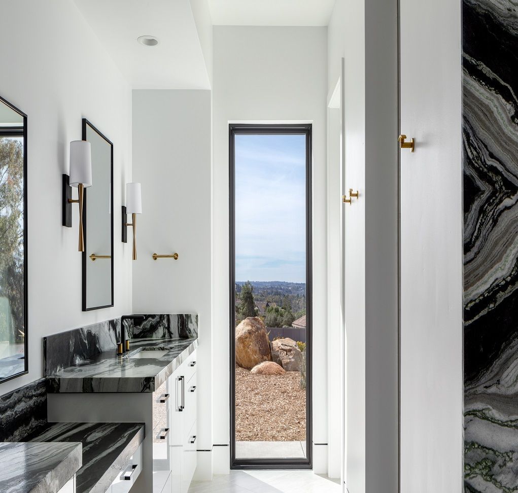 A bathroom with two sinks and a large window