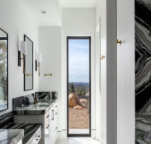 A bathroom with two sinks and a large window