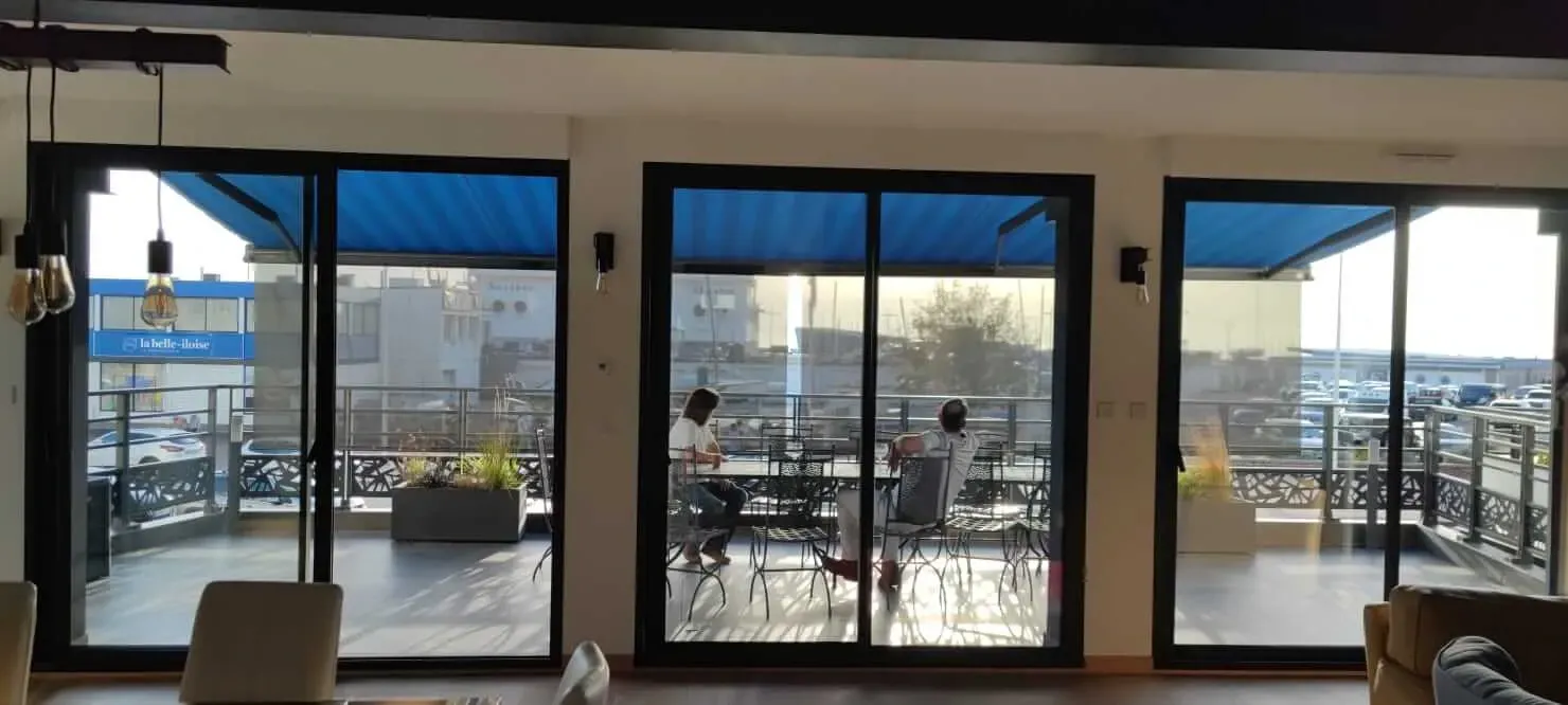 Un salon avec portes coulissantes en verre donnant sur un balcon.