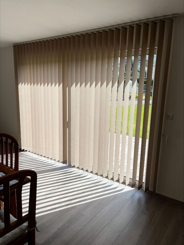 Un salon avec une porte coulissante en verre et des stores verticaux au Havre