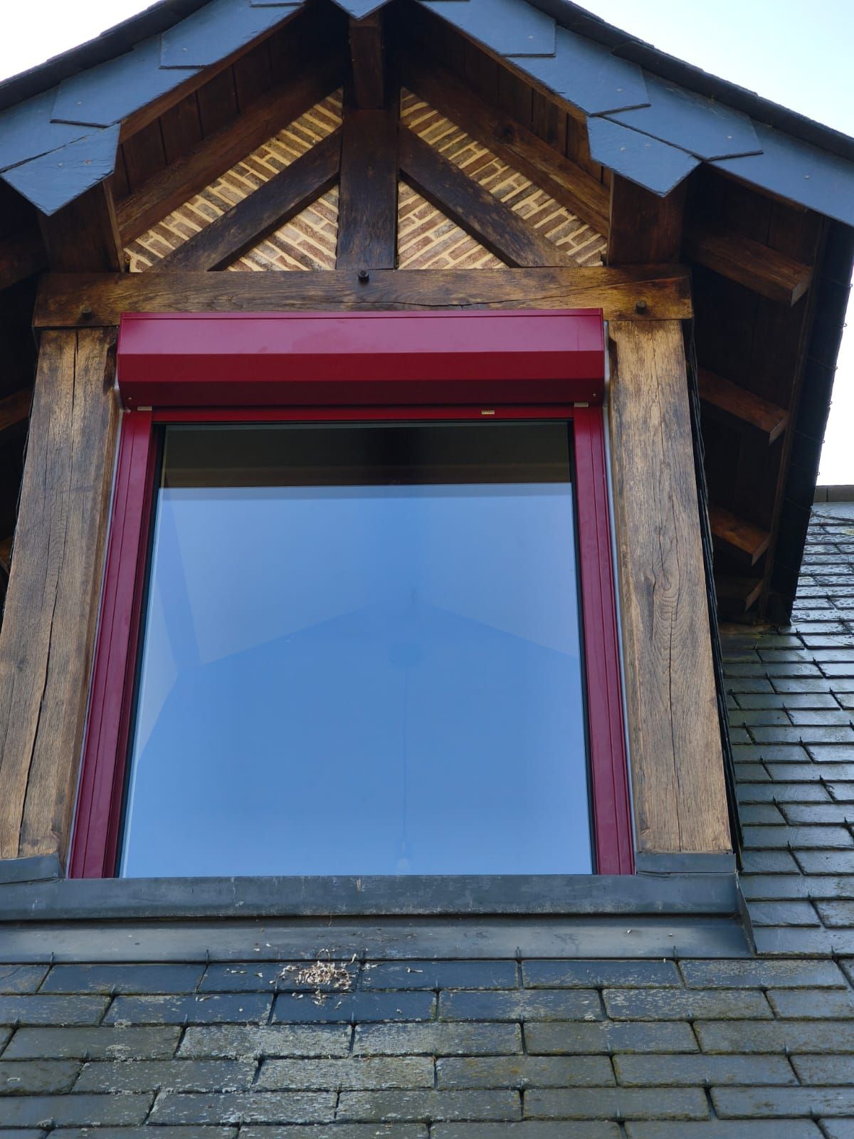 Une fenêtre PVC sur le côté d'un bâtiment avec un cadre rouge au Havre