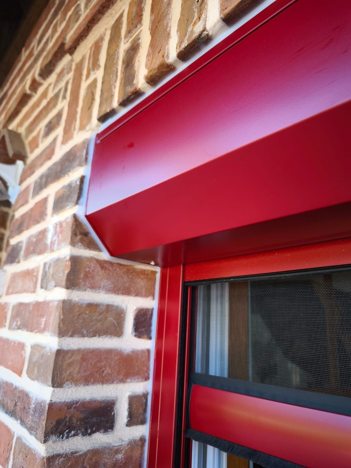 Un gros plan d'une fenêtre rouge sur un mur de briques