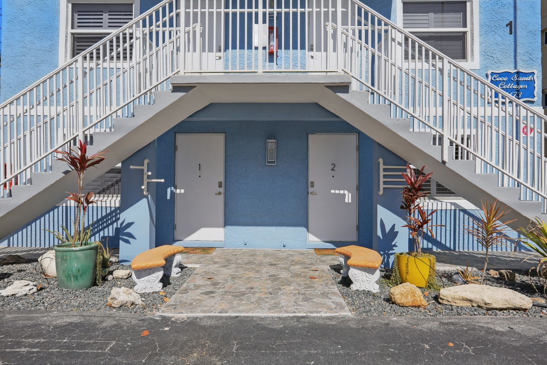 A blue building with stairs leading up to the second floor