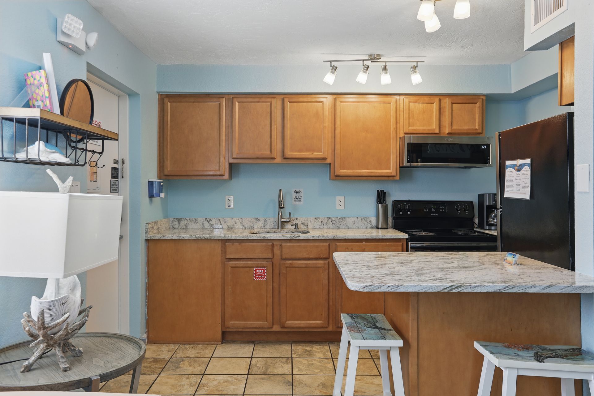 A kitchen with wooden cabinets and a black refrigerator