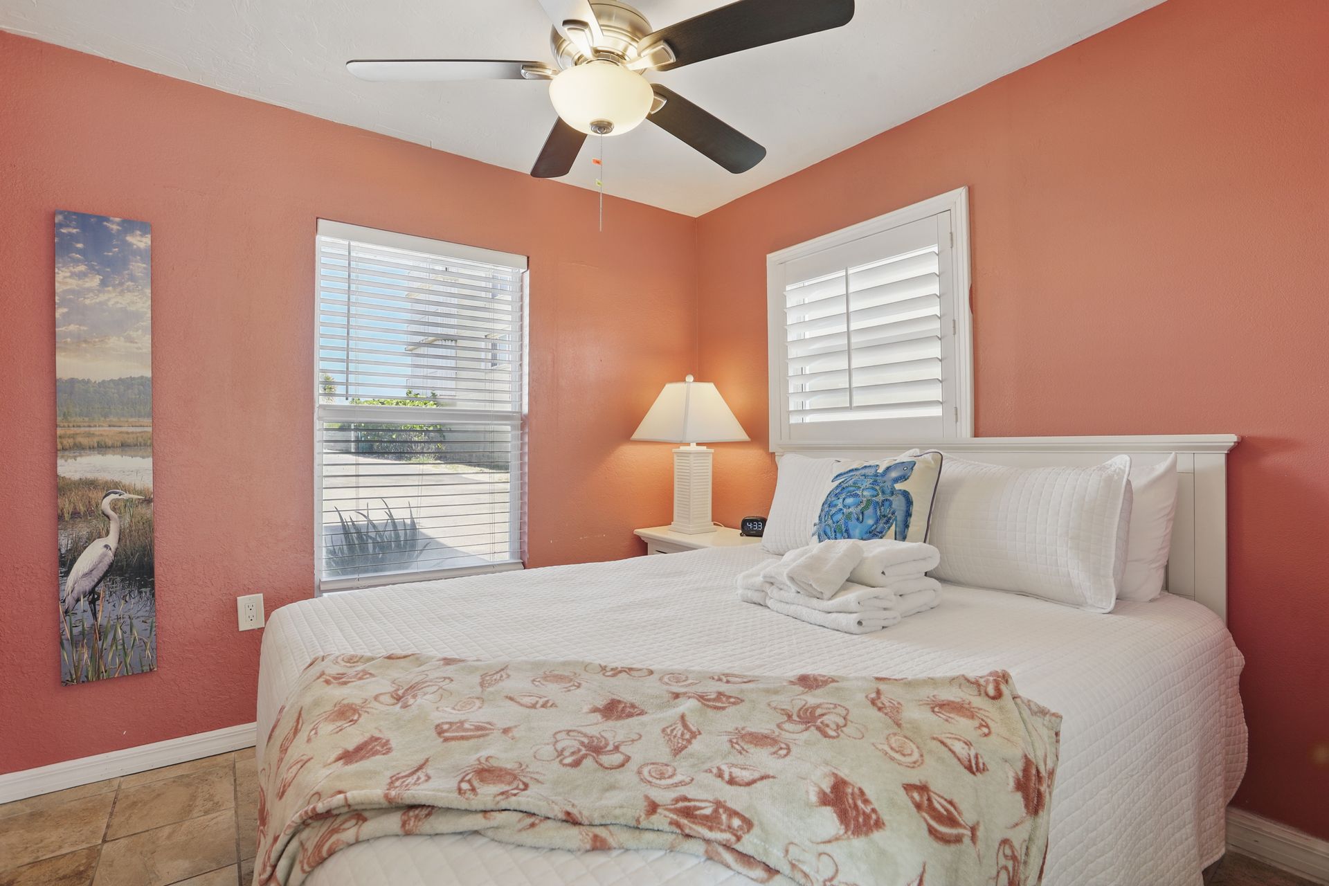 A bedroom with a king size bed and a ceiling fan.