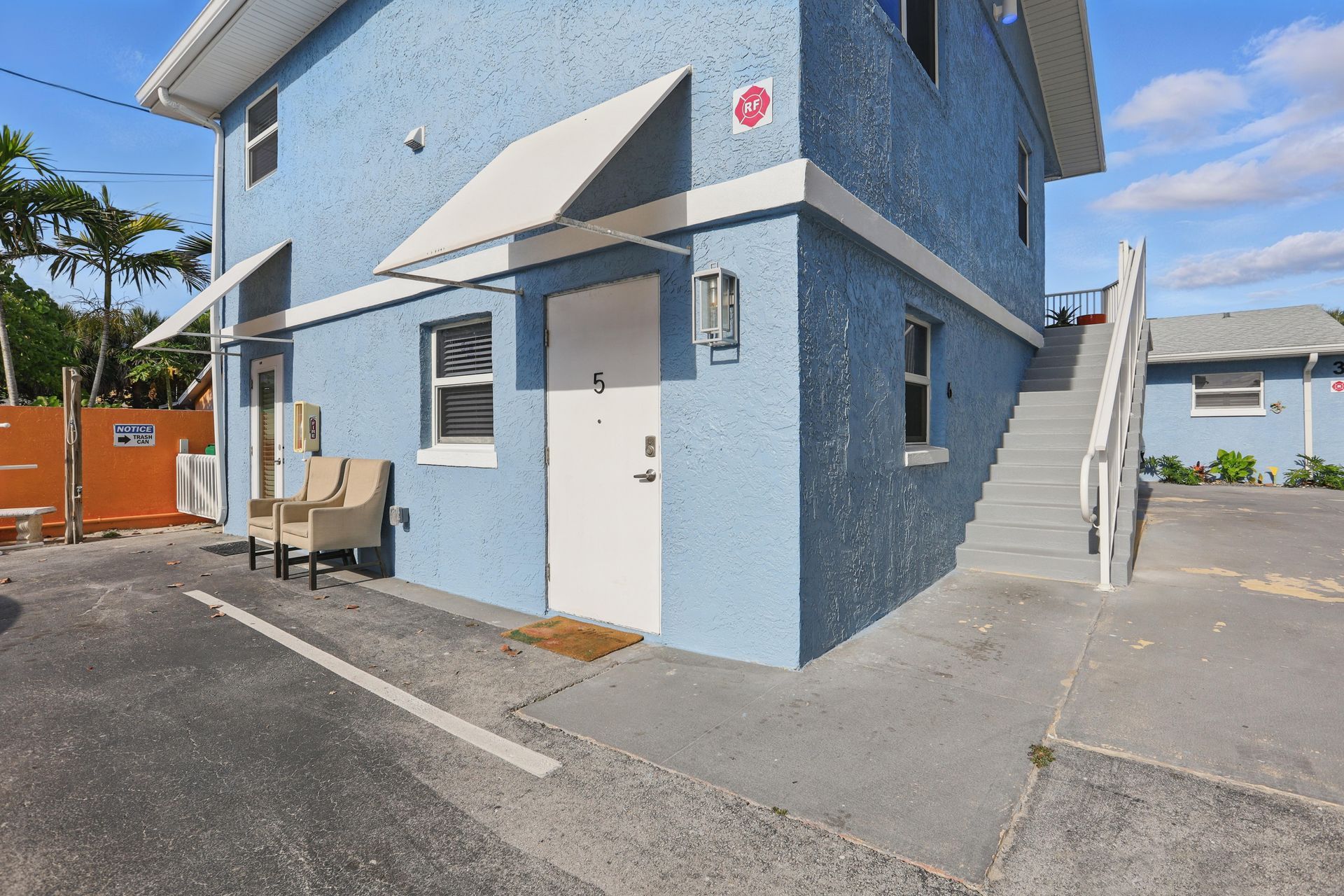 A blue building with stairs leading up to the second floor