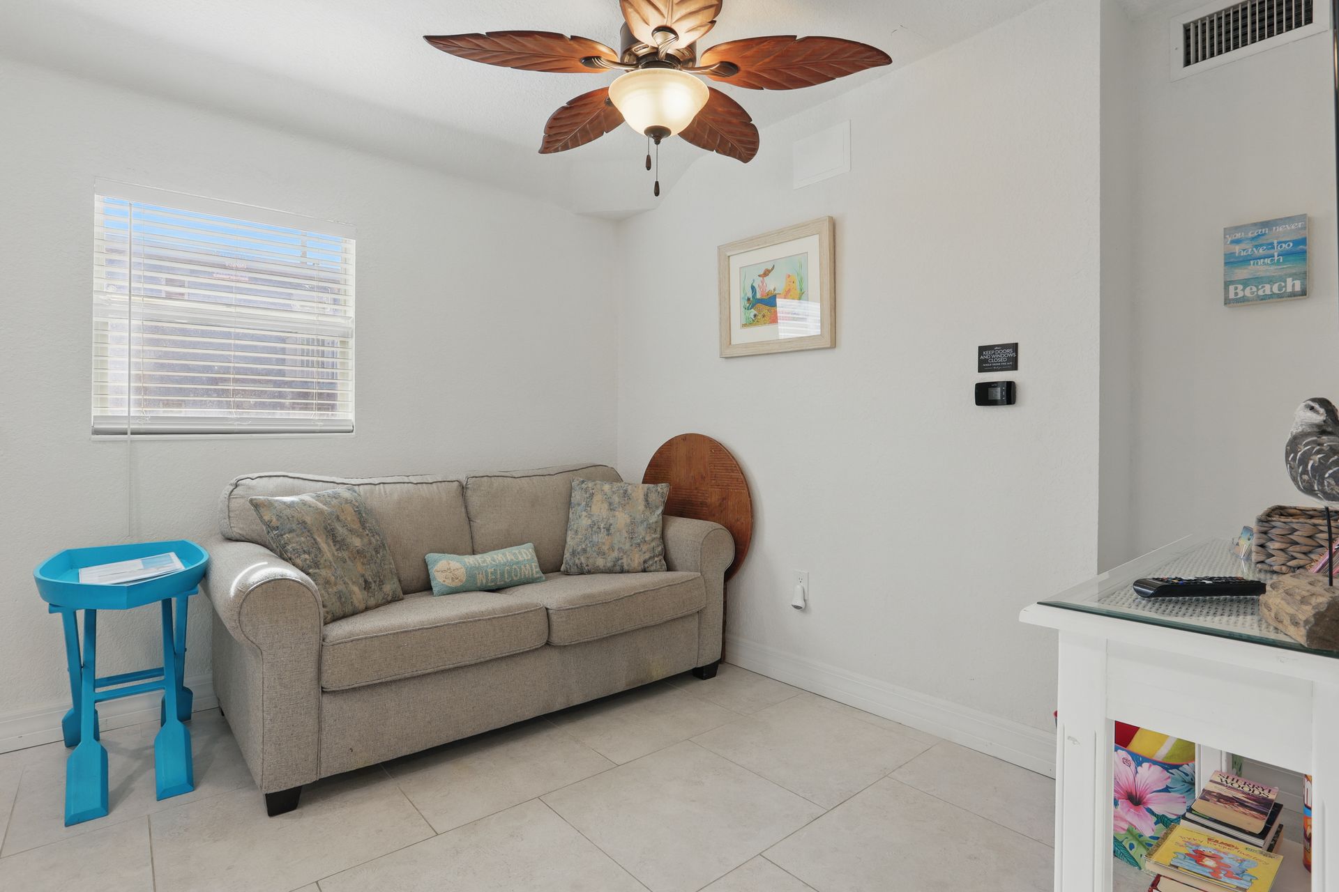 A living room with a couch and a ceiling fan.