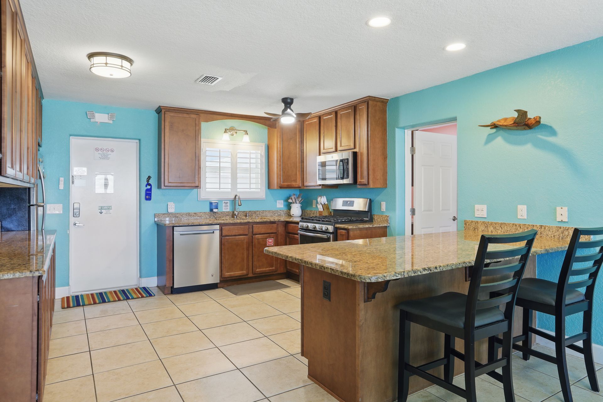 A kitchen with wooden cabinets , granite counter tops , stainless steel appliances and a large island.