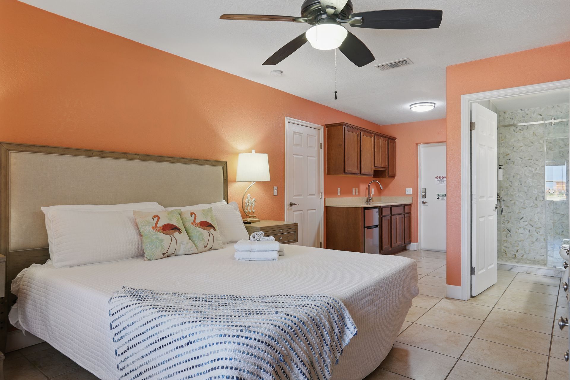 A bedroom with a king size bed and a ceiling fan.
