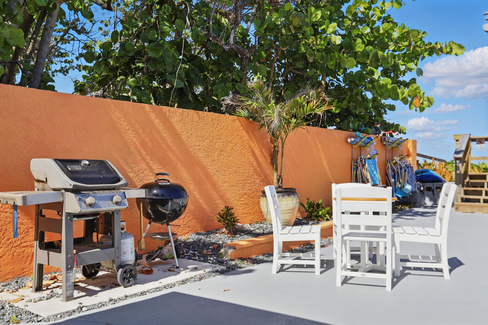 A patio with a table and chairs and two grills