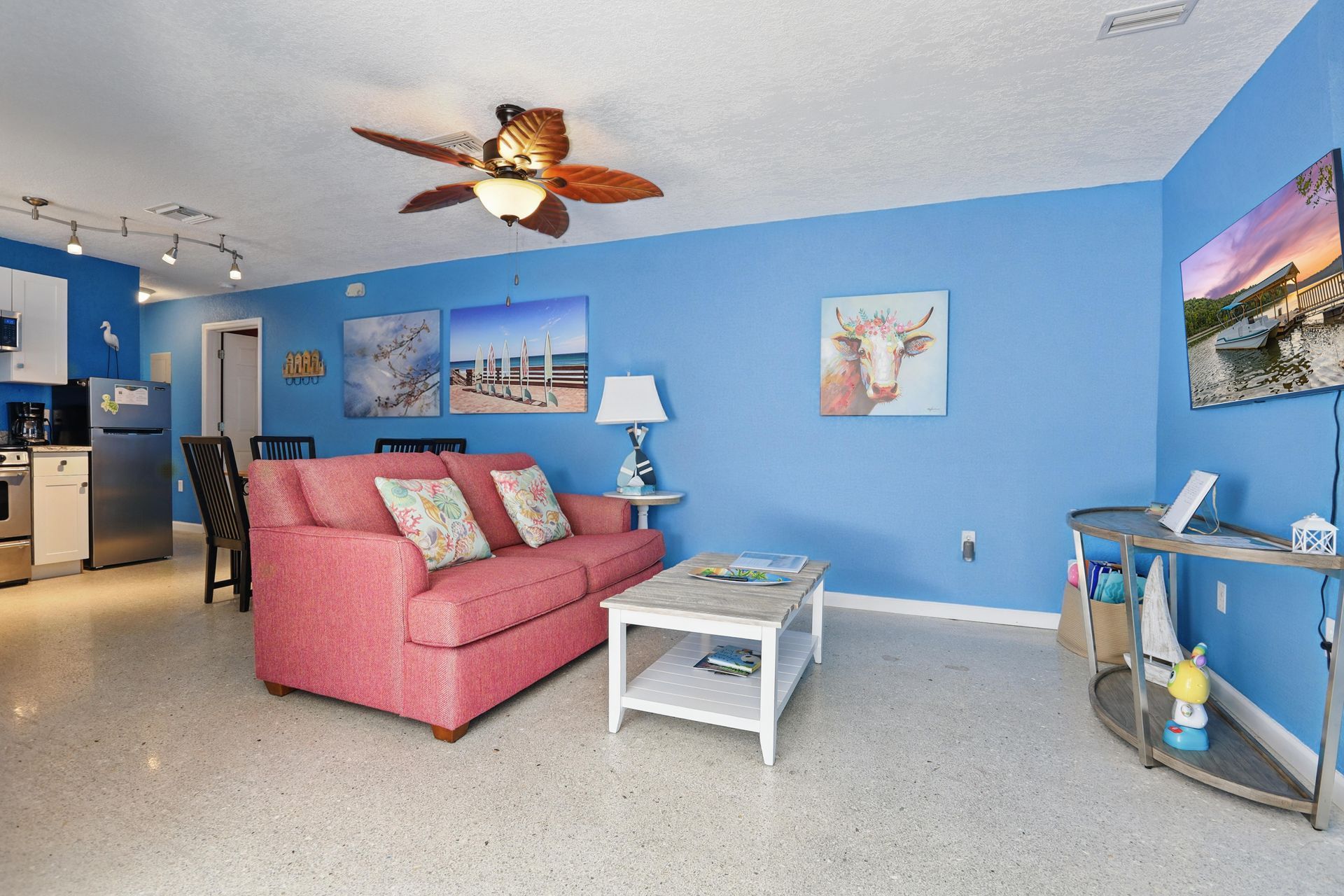 A living room with blue walls and a pink couch