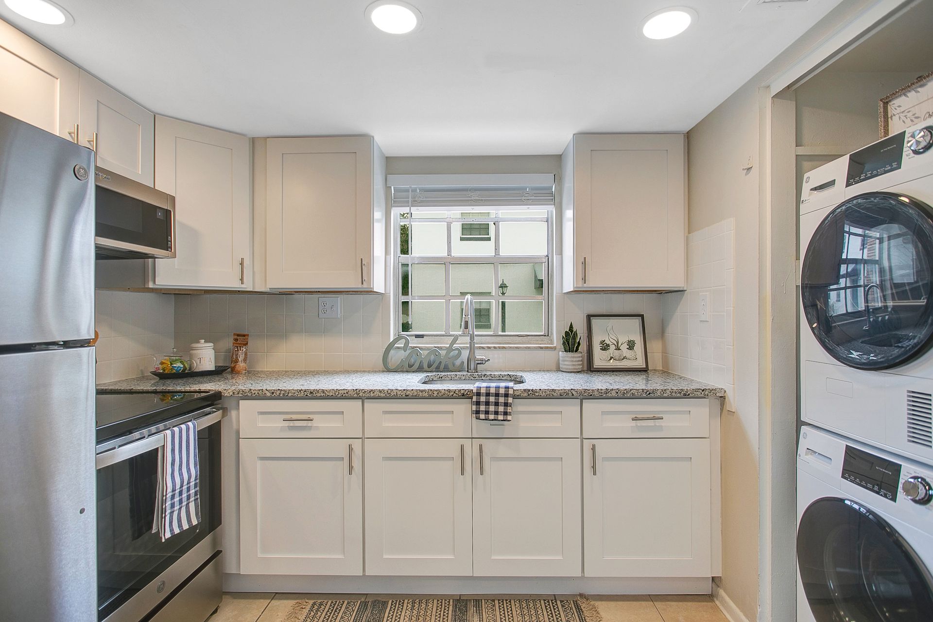 A washer and dryer are stacked on top of each other in a laundry room.
