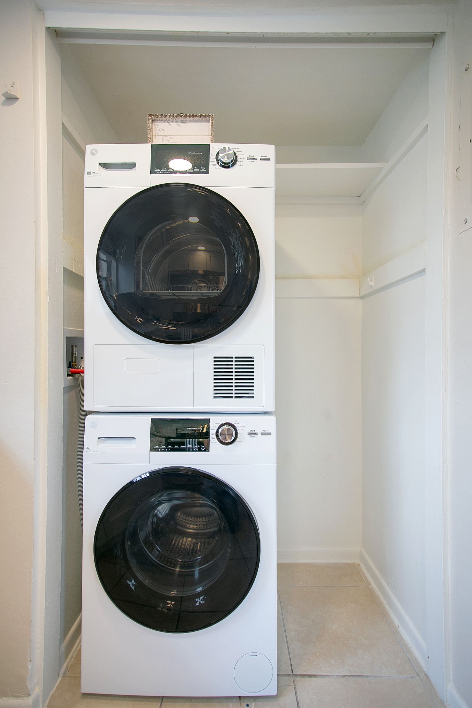 A laundry room with a washer and dryer stacked on top of each other.
