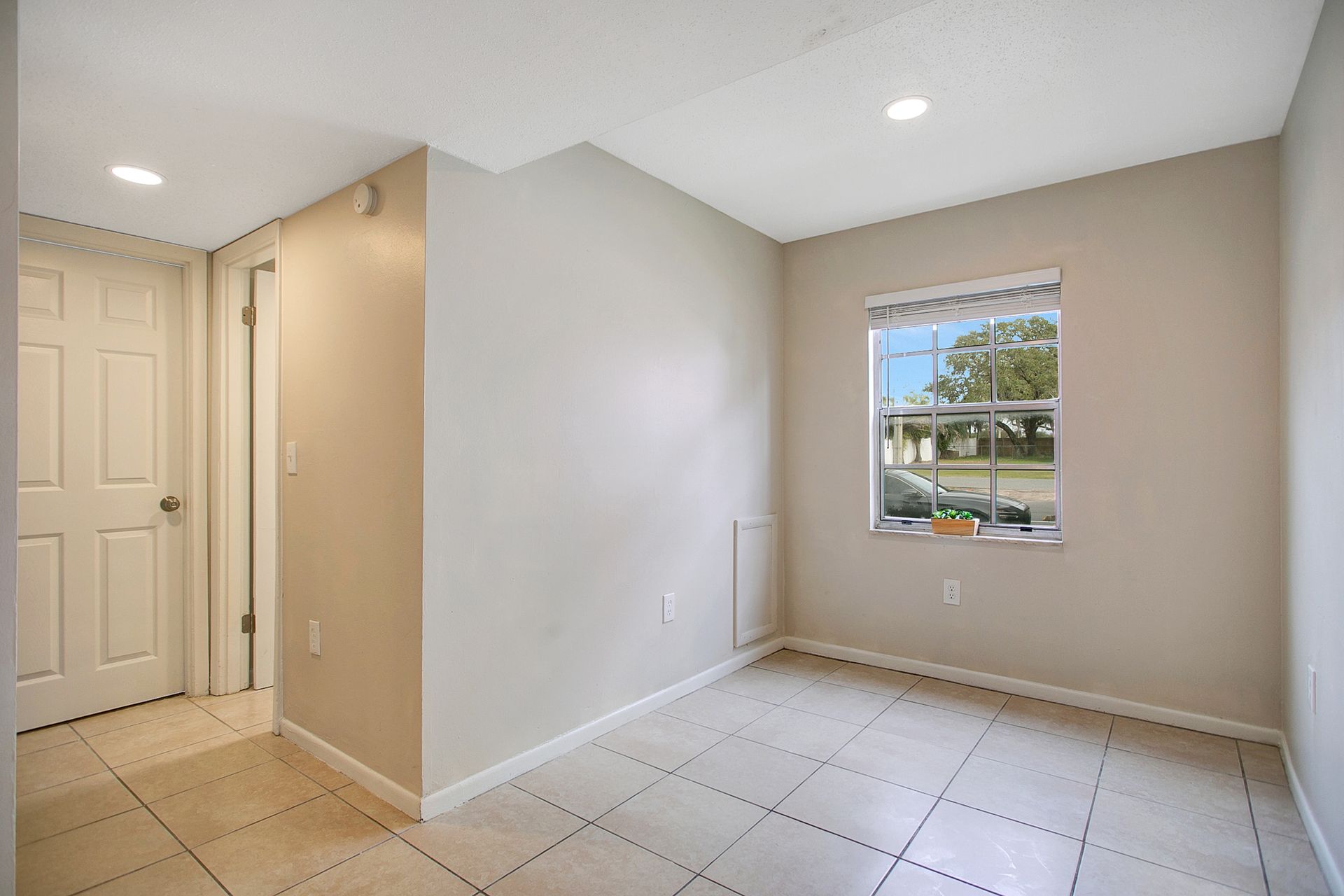 A kitchen with white cabinets , stainless steel appliances , granite counter tops and a window.
