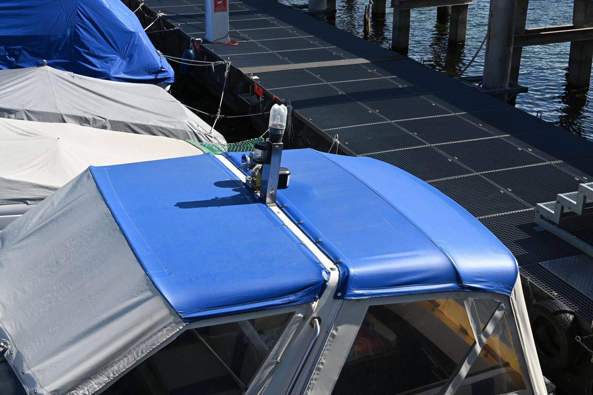 A boat with a blue roof is docked at a dock
