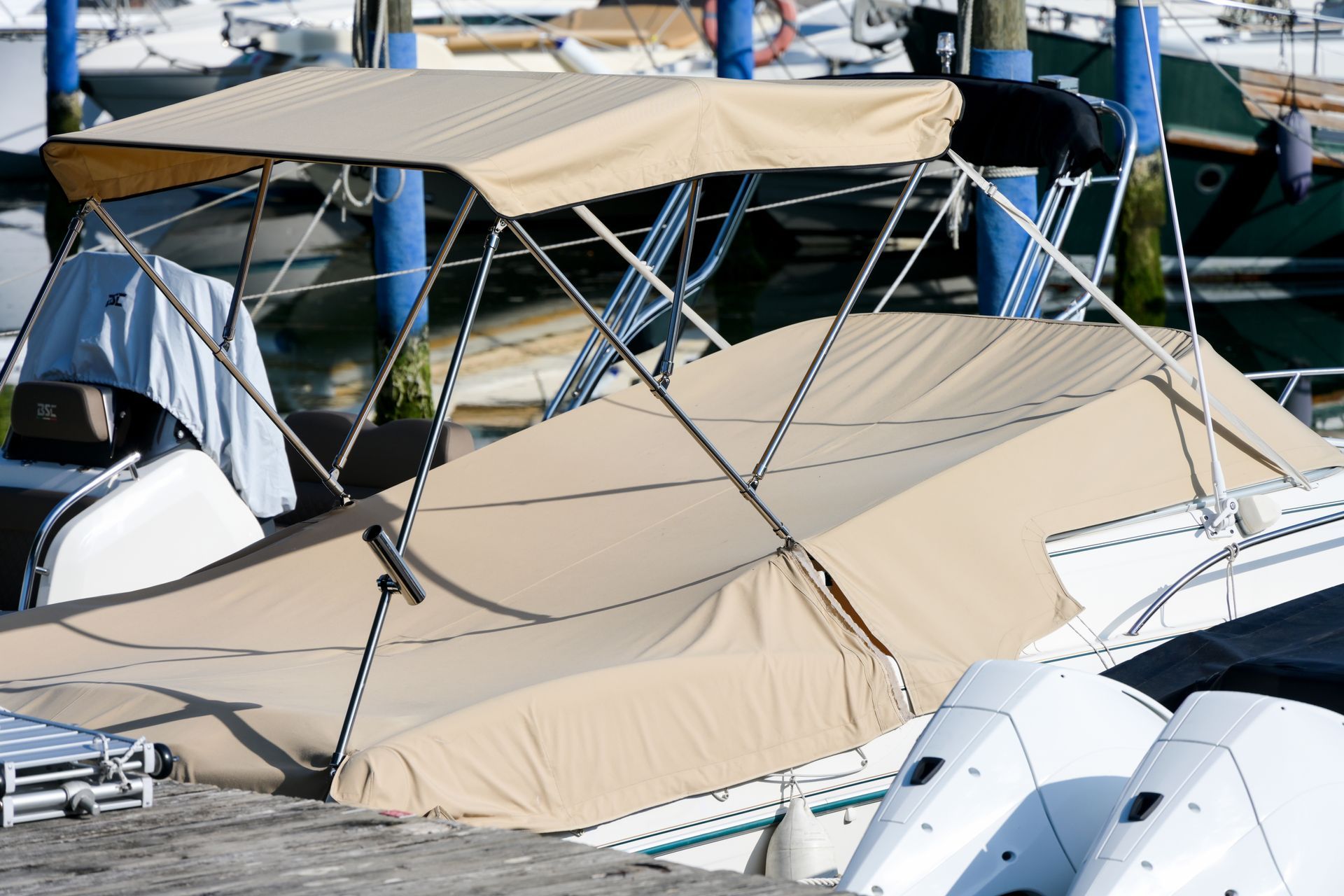 A boat with a canopy is docked at a marina