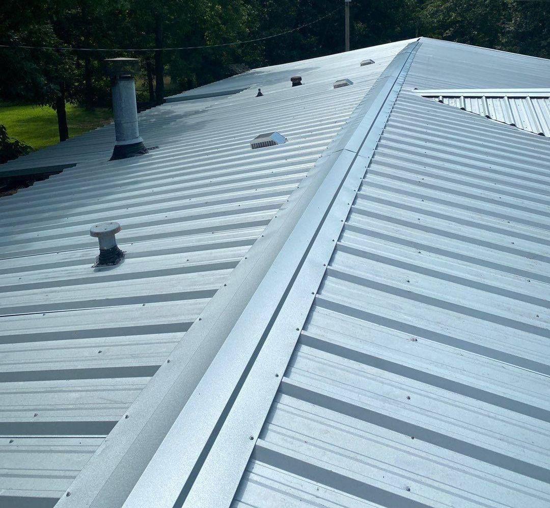 A close up of a metal roof with a chimney on it