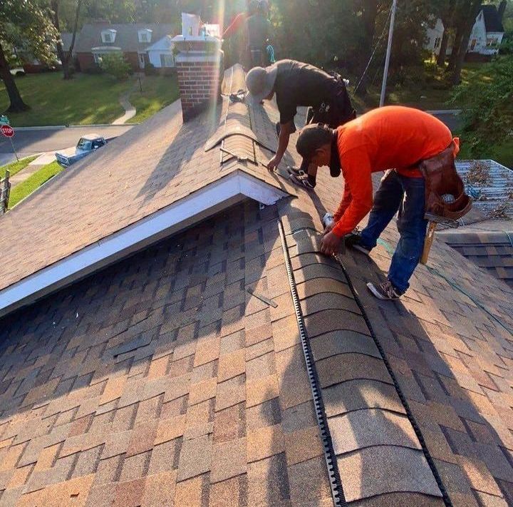 Two men are working on the roof of a house