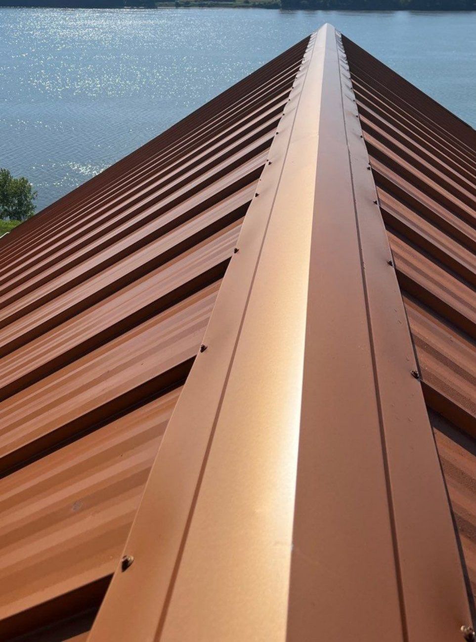 A brown roof with a lake in the background