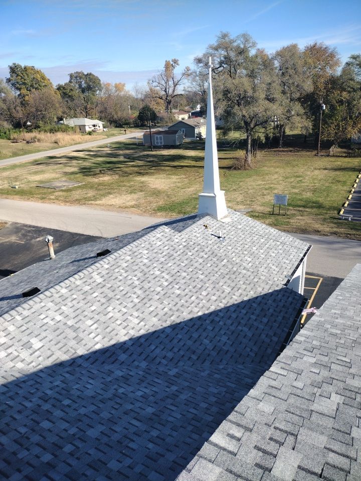 The roof of a church with a cross on top of it.