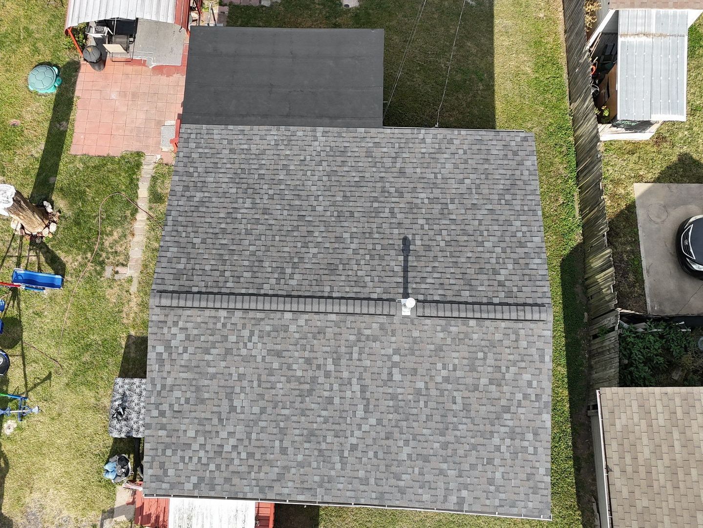 Two men are working on the roof of a house