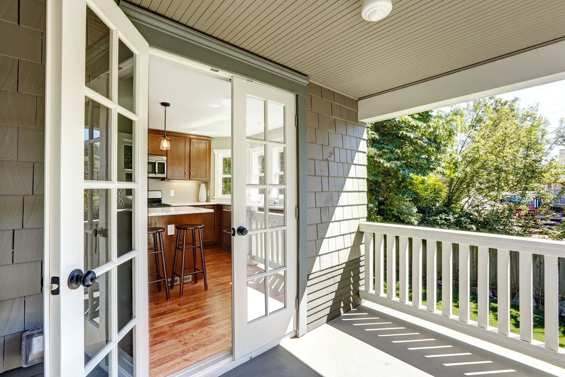 A porch with sliding glass doors leading to a kitchen.