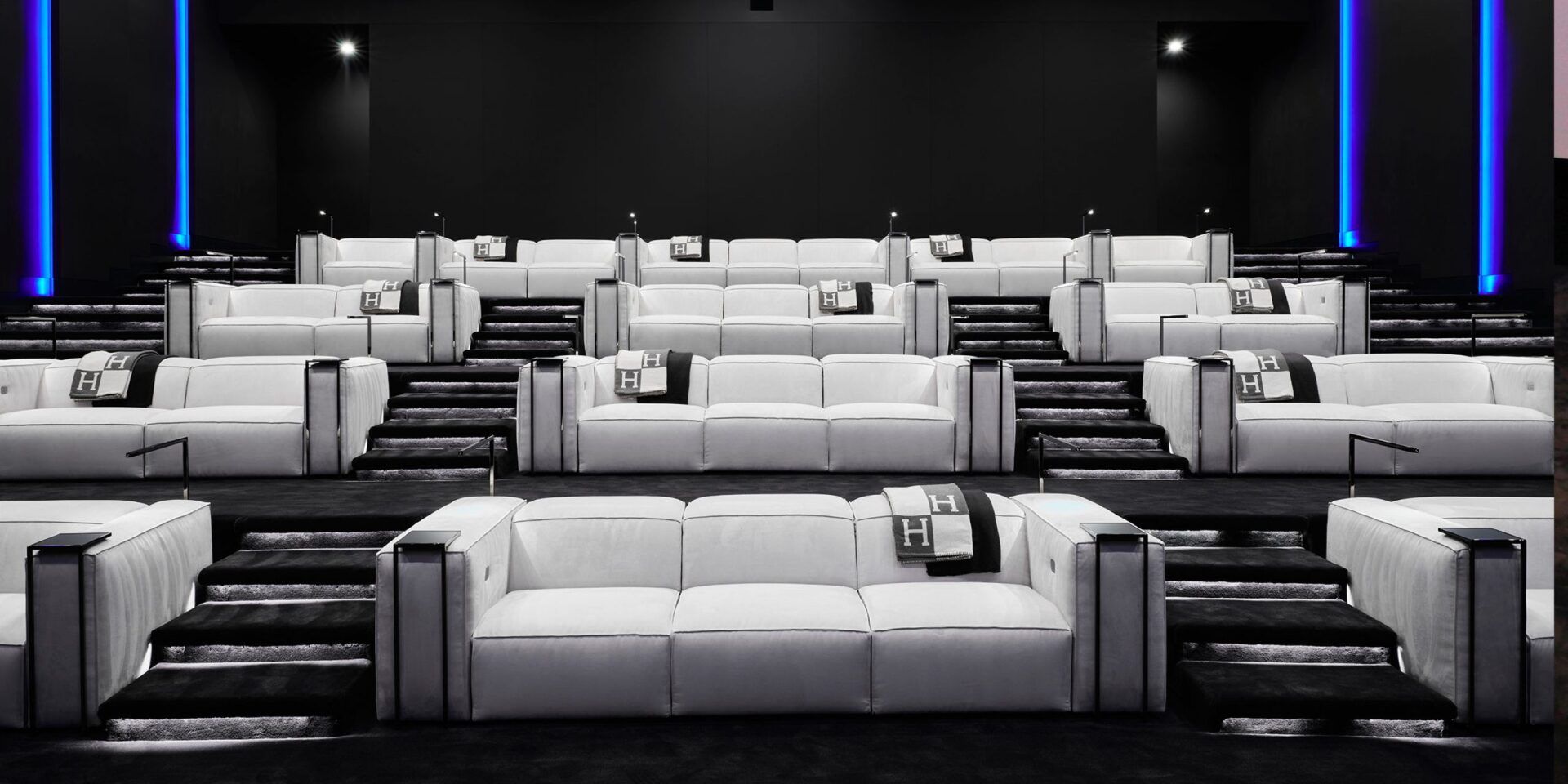A movie theater with a lot of white couches and chairs