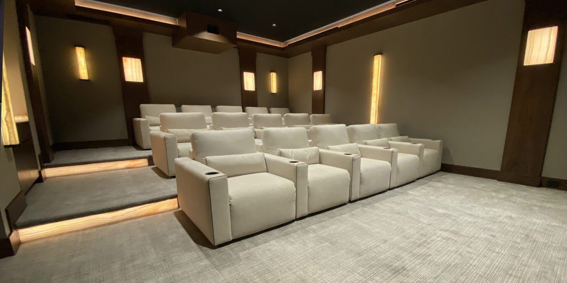 A home theater with white chairs and a projector.