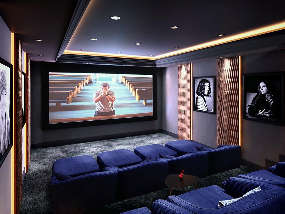 A home theater with a large screen and blue chairs