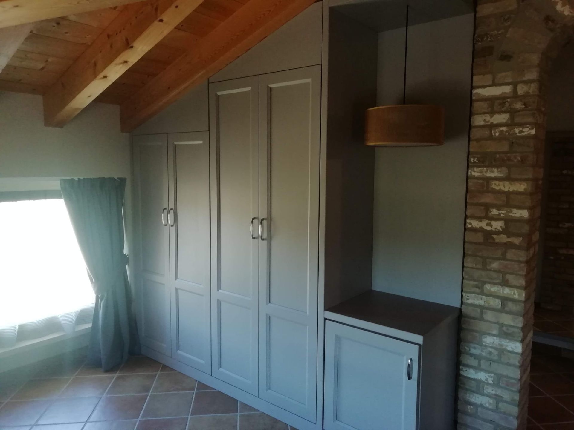 Una stanza con molti armadietti e un muro di mattoni.