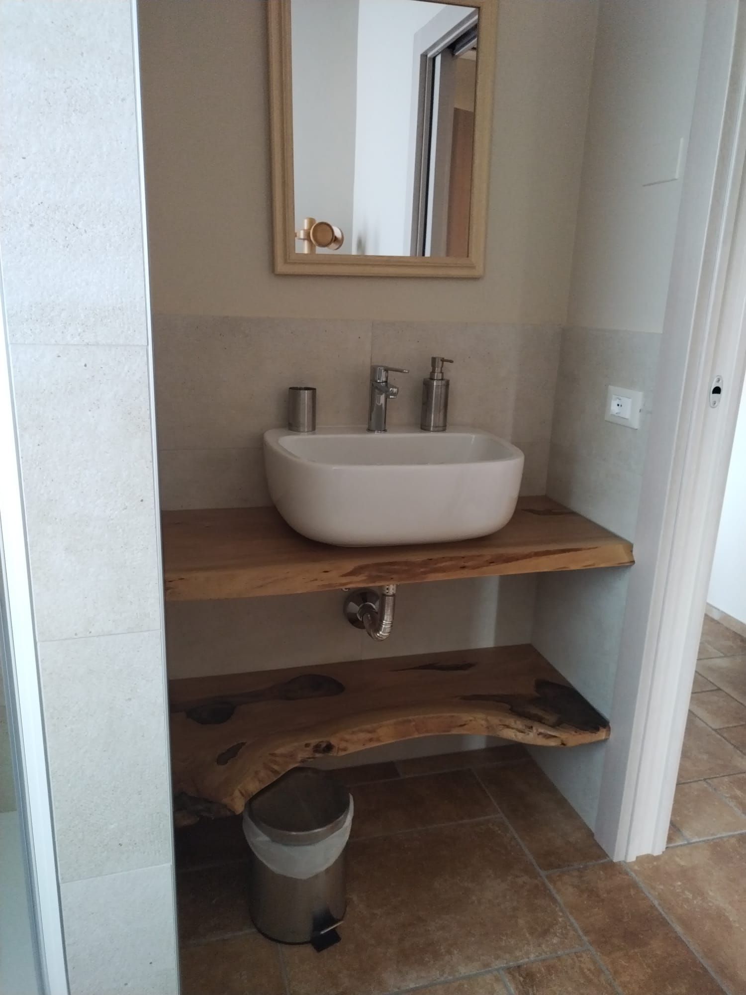 Un bagno con lavandino e specchio a parete.