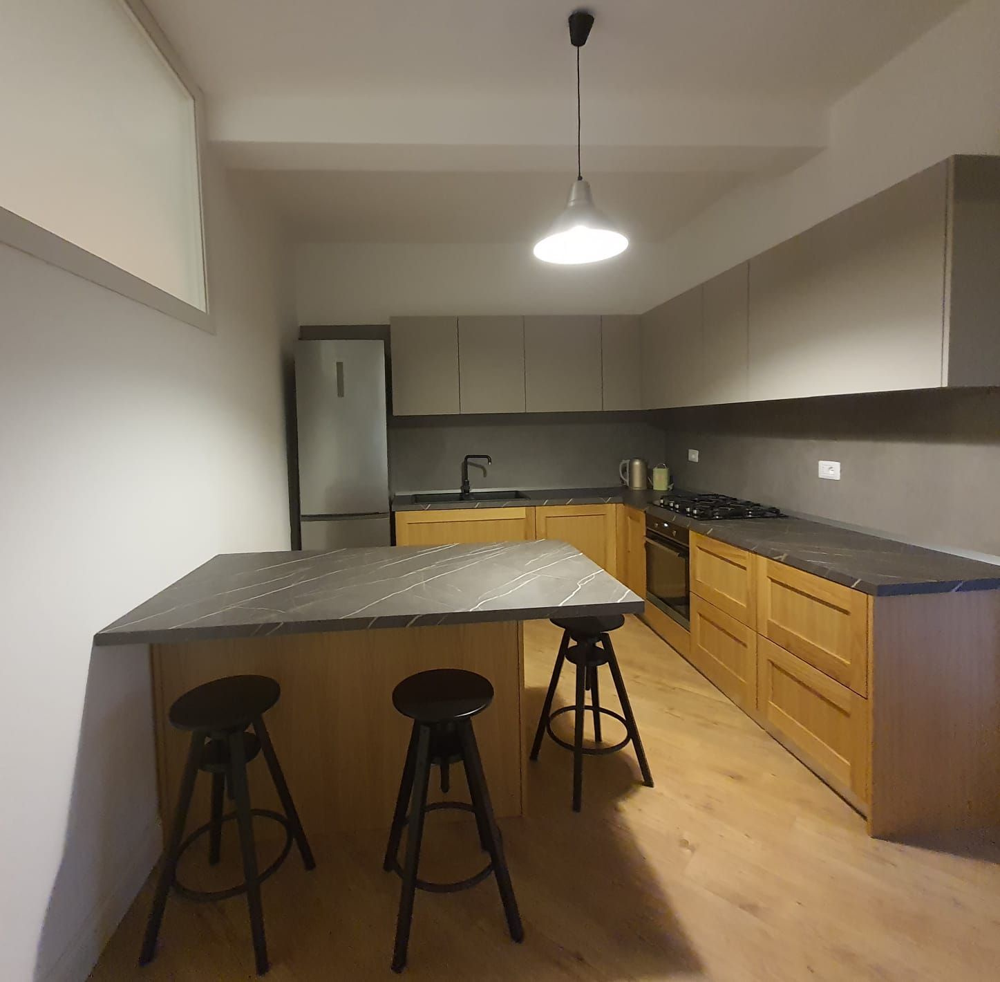 Una cucina con tavolo e sgabelli