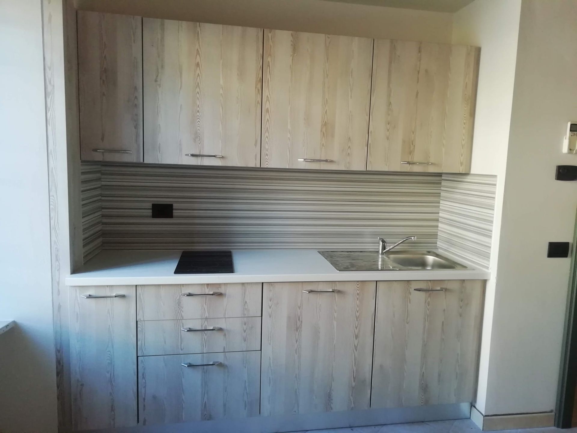 Una cucina con mobili in legno e un lavandino.