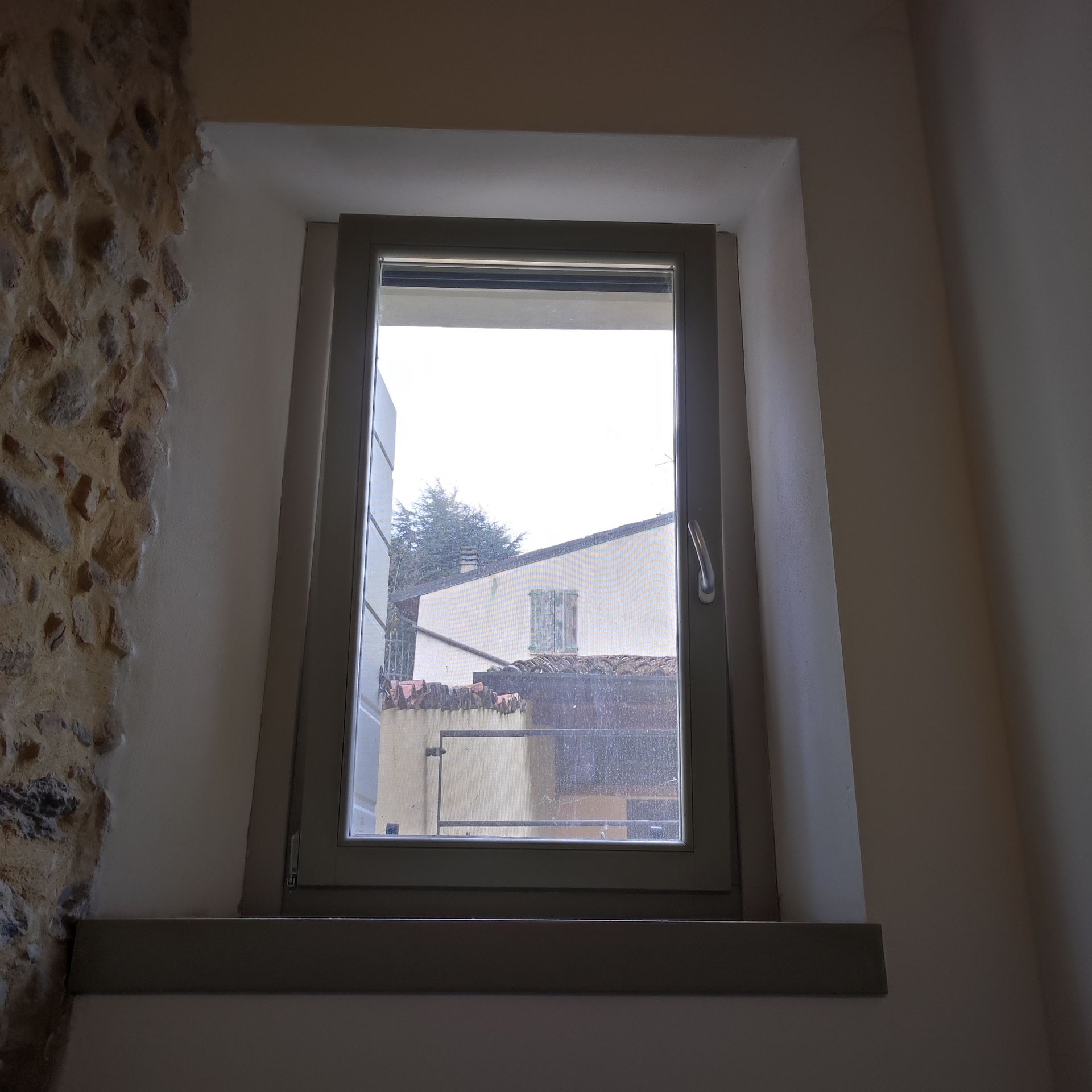 Una finestra con vista su un edificio in una stanza.