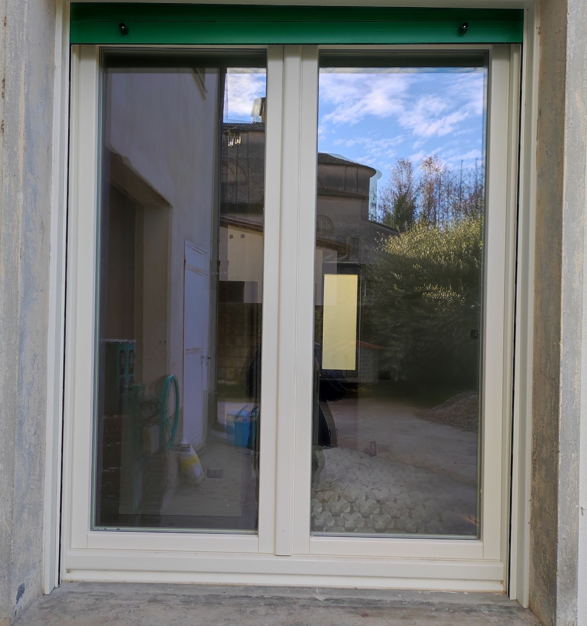 Una finestra bianca con una tenda verde