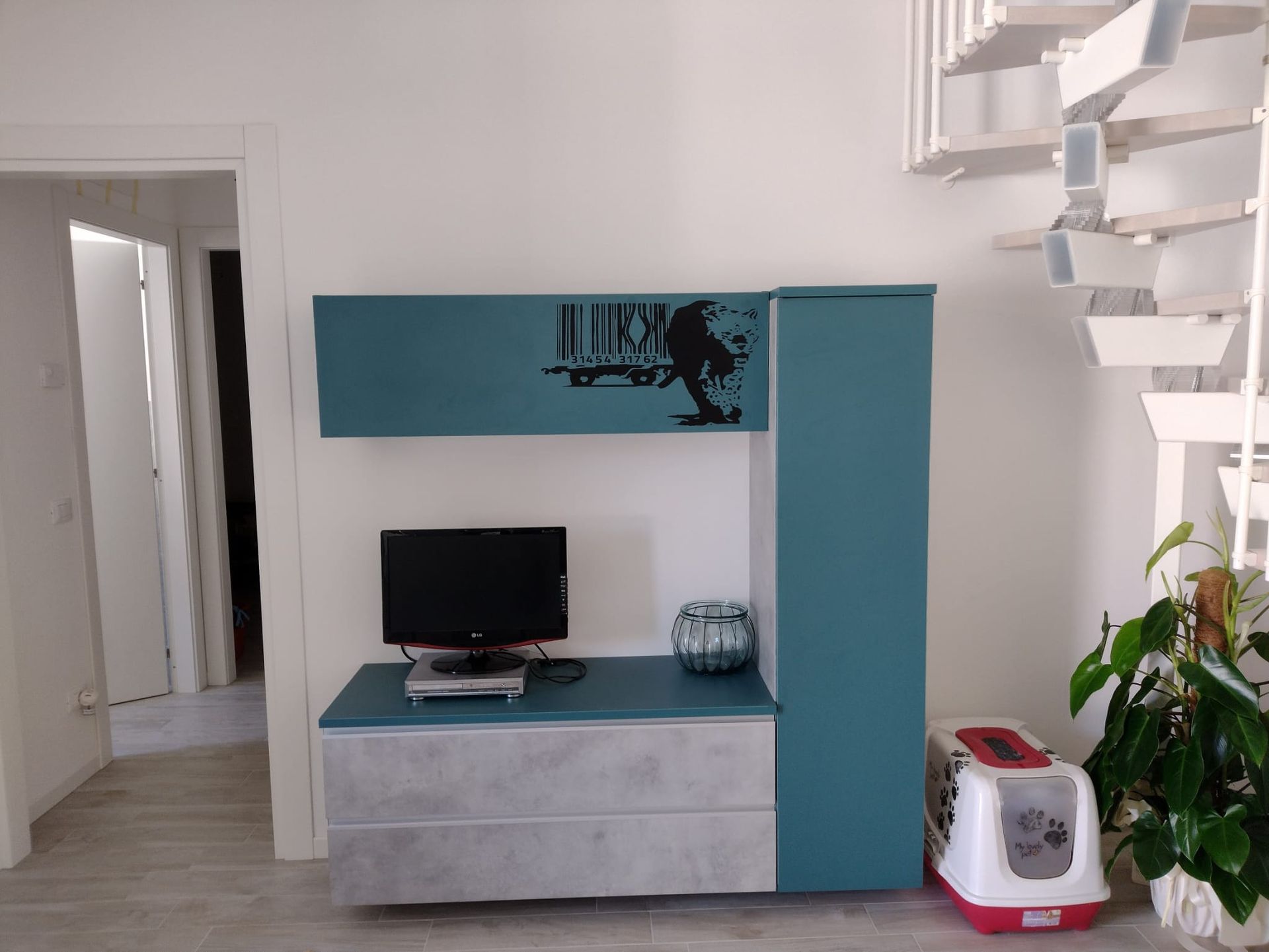 Un soggiorno con un computer e una lettiera per gatti