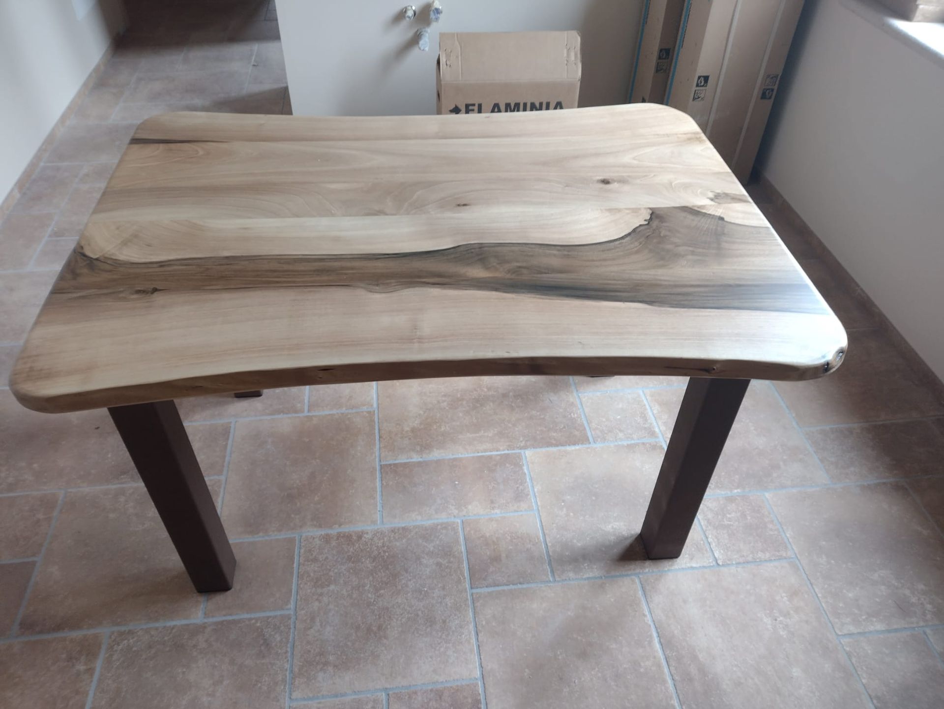 Un tavolo di legno è seduto su un pavimento piastrellato