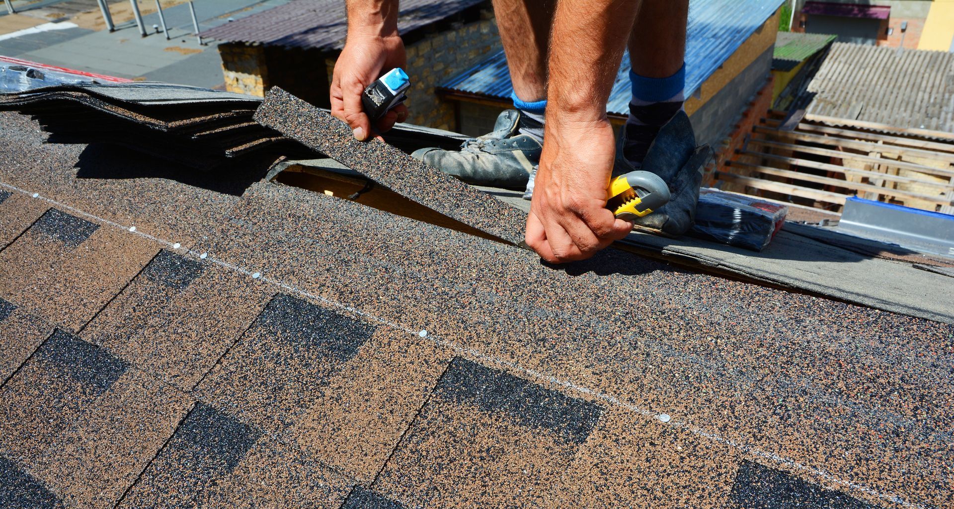 a man is installing shingles on a roof .