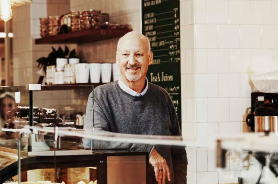 Ron Shaich leans against a counter at a bakery