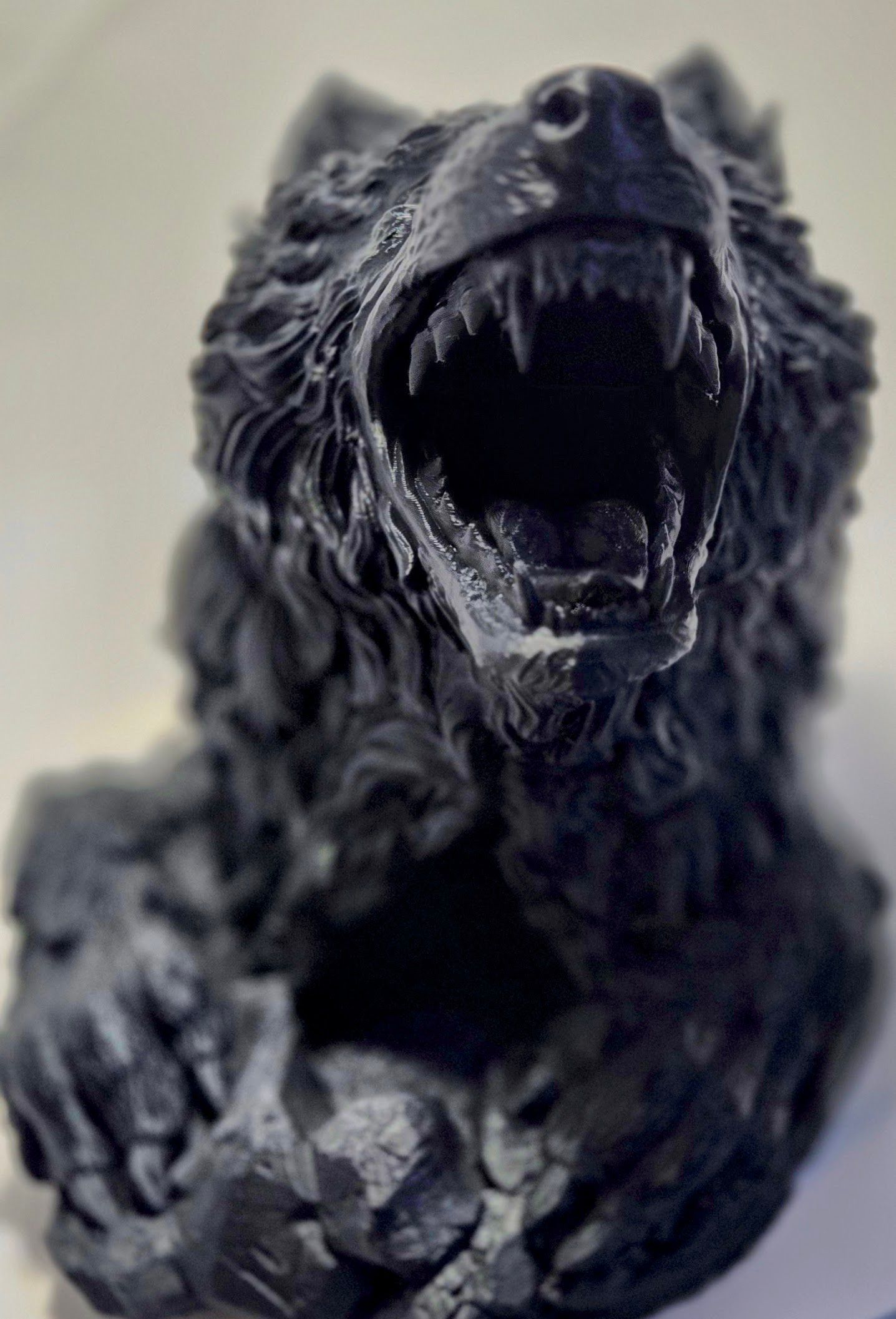 A black statue of a bear with its mouth open