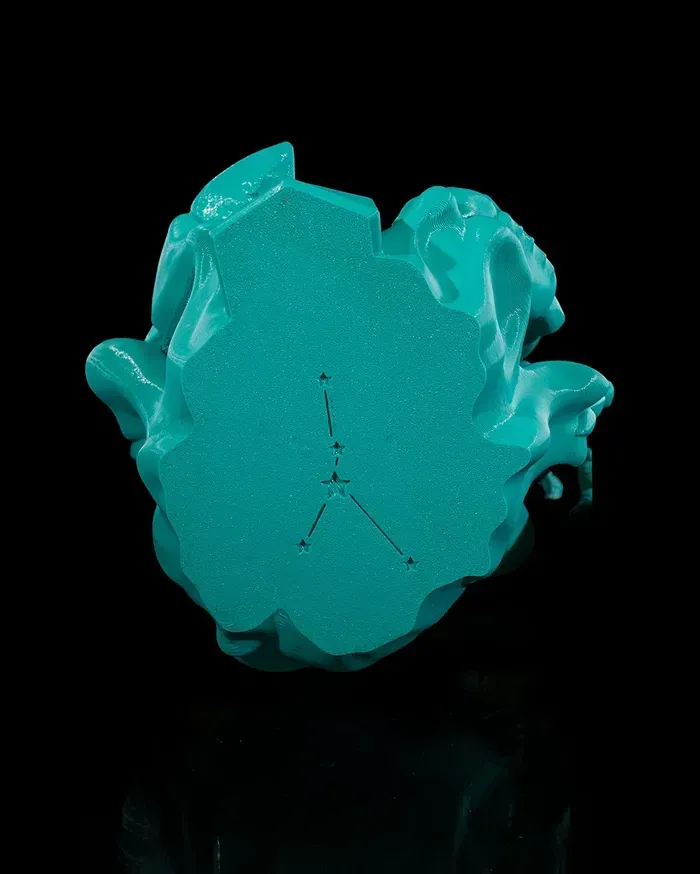 A turquoise crab with a yellow heart on its head