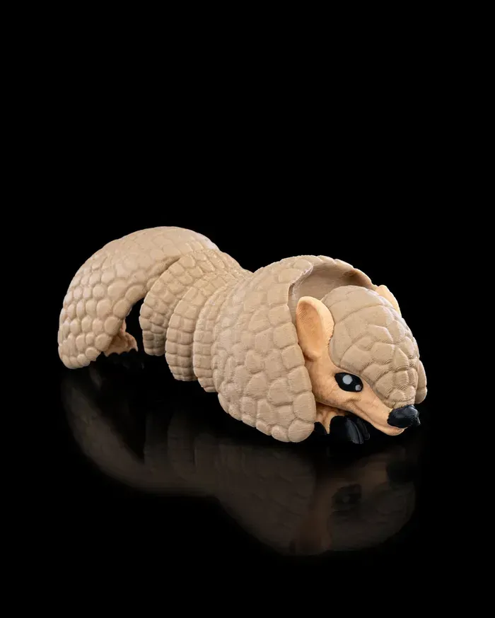 A close up of a toy armadillo on a black background.