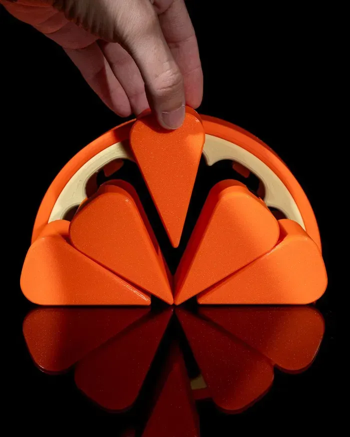 A slice of orange is sitting on a black surface